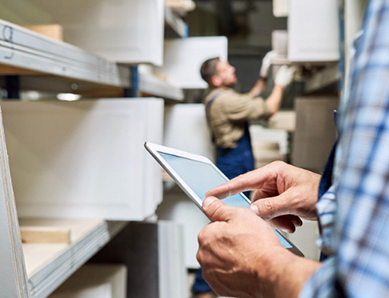 Employee using a CMI iPad in a warehouse aisle