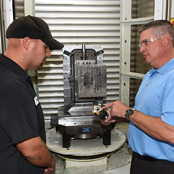 Mars Supply field sales rep reviewing a machining fixture with a customer on the shop floor